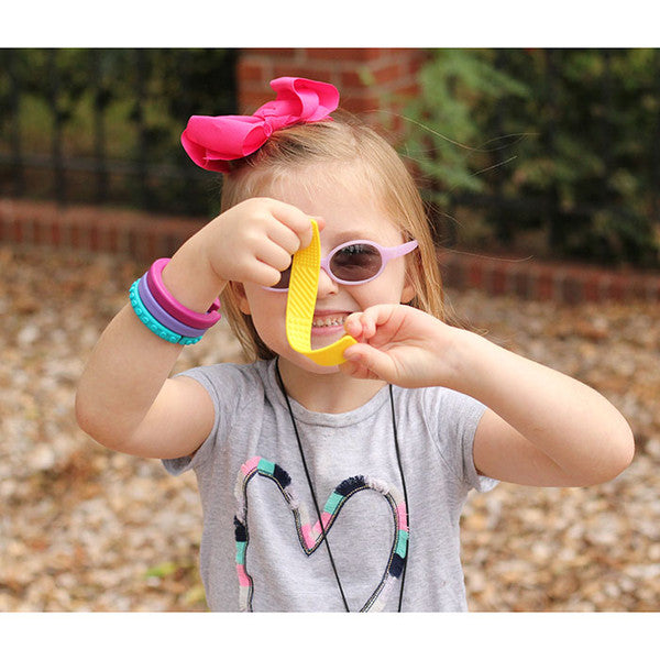 smiling_girl_fidgeting_with_ARK's_Sensory_Bookmark /_Fidget